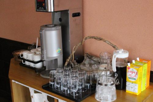 a counter with a coffee maker and glasses on it at Toyooka Sky Hotel in Toyooka