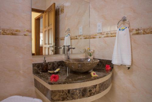 un bagno con lavandino e specchio di Seashell Beach Villa a Grand'Anse Praslin