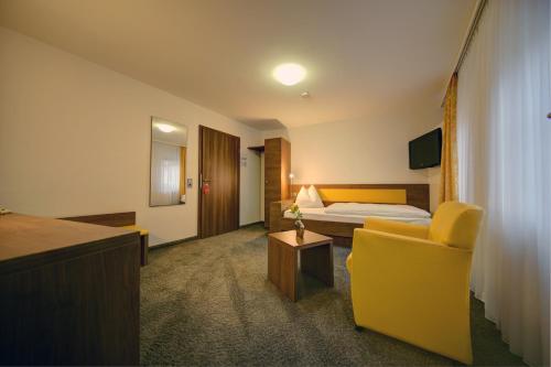 En eller flere senge i et værelse på Hotel Adler