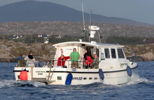 a group of people on a boat in the water at Harbour front apartments in Burtonport
