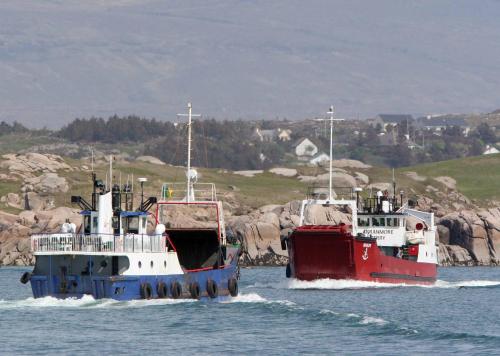 two boats in the water next to each other at Harbour front apartments in Burtonport