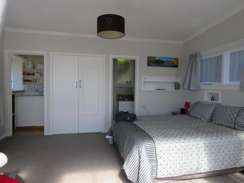 a bedroom with a bed and a kitchen at Oamaru Harbour Nest in Oamaru
