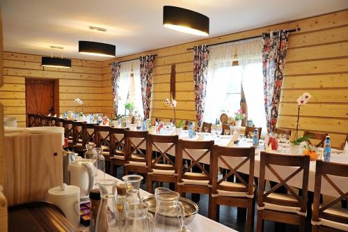 Chata u Rysia في Hoczew: غرفة طعام طويلة مع طاولات وكراسي