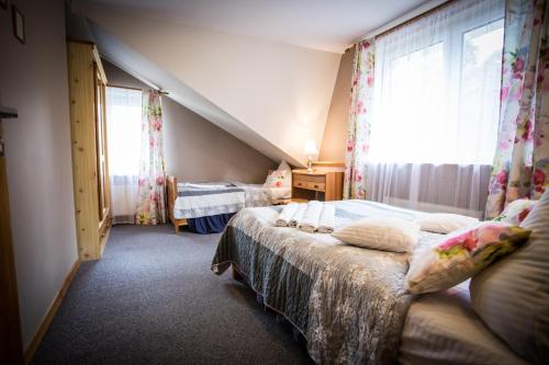 a bedroom with two beds and a window at Anielski Zakątek Polańczyk in Polańczyk