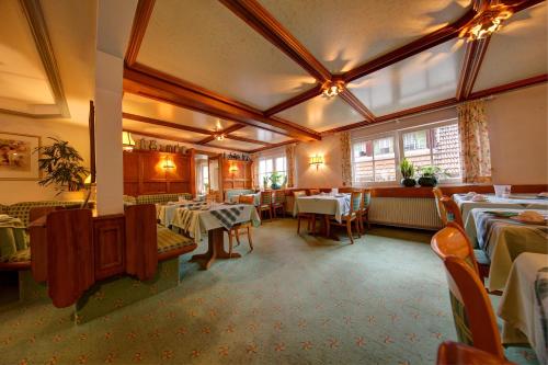 a restaurant with tables and chairs in a room at Hotel Adler in Nagold