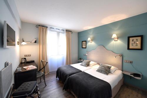 a hotel room with a bed and a window at The Originals Boutique, H&ocirc;tel du Parc, Cavaillon in Cavaillon