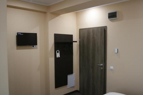 ein Zimmer mit einer Tür und einem Fernseher an der Wand in der Unterkunft Liador in Câmpia Turzii