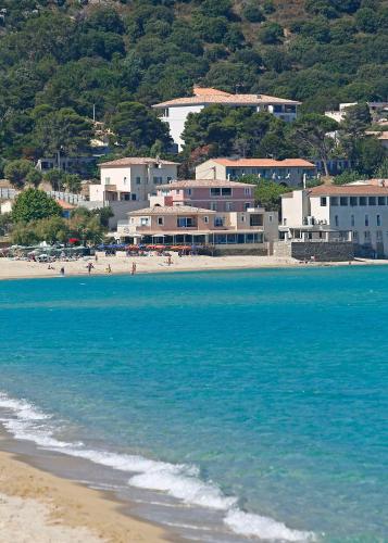 a group of people on a beach near the water at Hôtel Serenada in Algajola