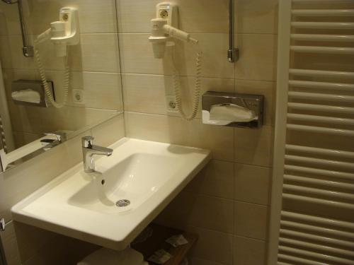 a bathroom with a sink and a phone on the wall at Hotel Löhr in Baden-Baden