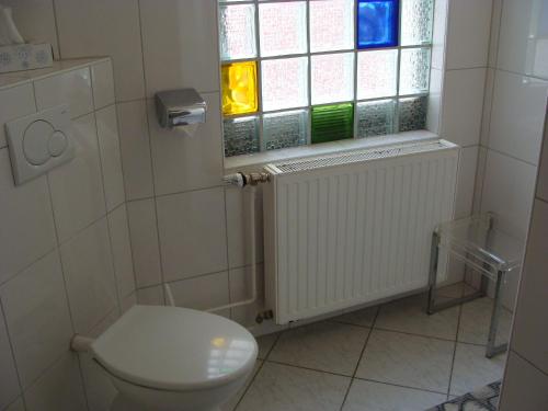 a bathroom with a toilet and a window at Hotel Löhr in Baden-Baden