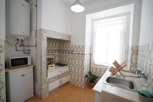 a small kitchen with a sink and a window at Mouraria Apartments in Lisbon