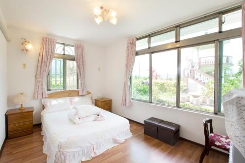 a bedroom with a bed and a large window at Taitung Moon House in Luye