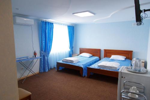 ArtemivsʼkにあるHotel Bakhmutのベッド2台と窓のある病室です。