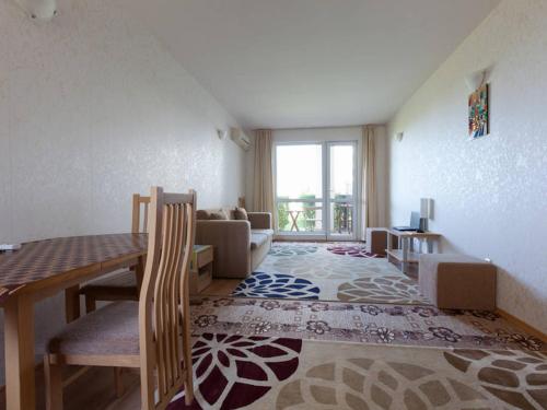 un soggiorno con tavolo da pranzo e un soggiorno con finestra. di Panoramic Sea View Apartment a Ravda