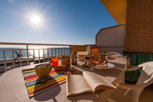 un tavolo con un libro su un balcone soleggiato di Il Mare In Giardino a Scauri