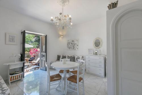 a dining room with a table and chairs and a chandelier at Villa Sunrise in Hydra