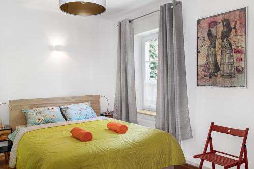 ワルシャワにあるEvva & Peppe Old Town Flatのベッドルーム1室(オレンジ色の枕が付いたベッド1台付)