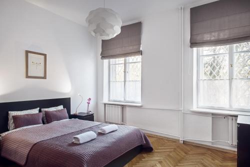 1 dormitorio con 1 cama con 2 toallas en Bednarska Old Town Apartment, en Varsovia
