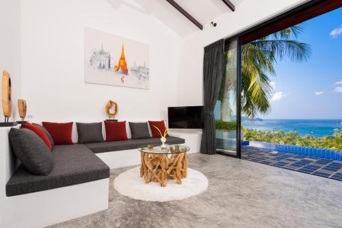 a living room with a couch and a table at The Plantation Koh Tao in Koh Tao