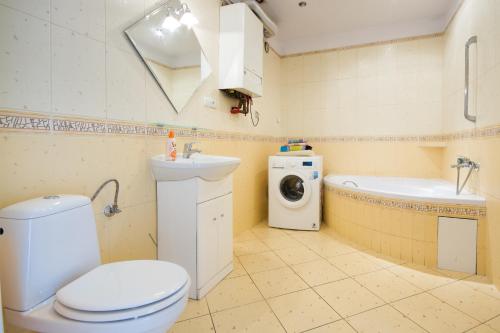 a bathroom with a toilet and a sink and a washing machine at 3 Bros' Apart in Cieszyn