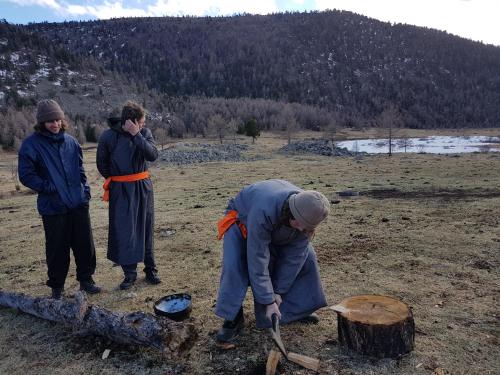 a group of people standing around a tree stump at Vast Mongolia Tour & Hostel in Ulaanbaatar