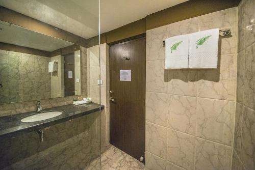 a bathroom with a sink and a mirror at The Fern Residency Kolkata in Kolkata