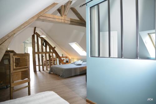 - un salon avec un lit et un escalier dans l'établissement Chambres d'hôtes Ferme du Feugrès, à Saint Germain la campagne