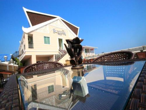 einen Tisch mit einer Spiegelung eines Hauses im Wasser in der Unterkunft Suntosa Resort in Ko Larn