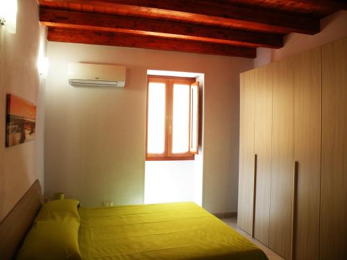 シラクーサにあるAl Blu Ortigia Apartmentsのベッドルーム(緑のベッド1台、窓付)