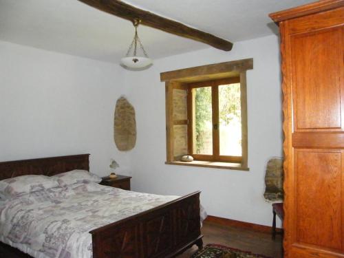 a bedroom with a bed and a window at Pear Tree Gite in Génis