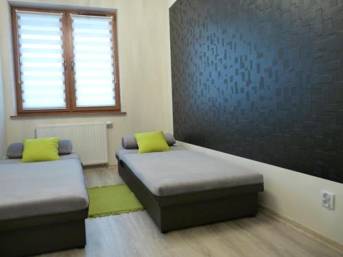 Cette chambre comprend 2 lits, une fenêtre et un canapé. dans l'établissement Apartament Sandra, à Karpacz