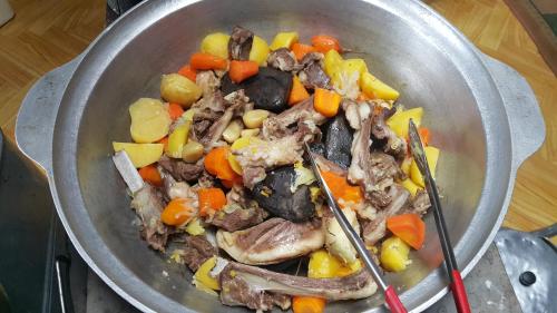a pot full of food with meat and vegetables at Vast Mongolia Tour & Hostel in Ulaanbaatar