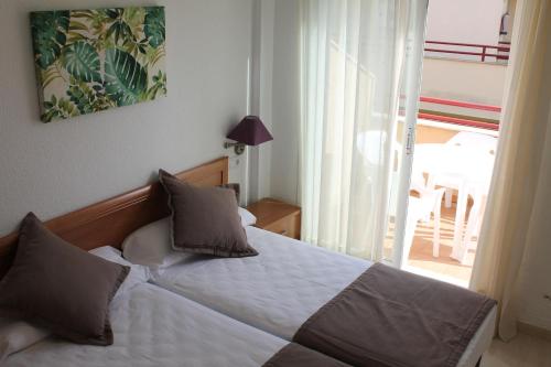 a bedroom with a bed and a window with a patio at Apartamentos Turisticos Caños de Meca in Los Caños de Meca