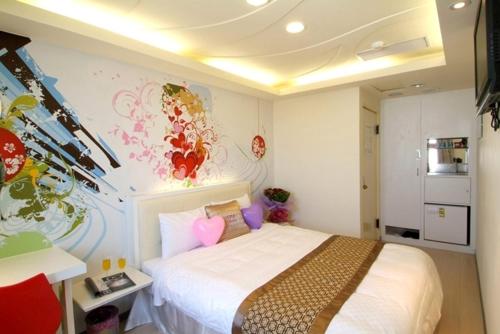 a bedroom with a bed and a wall with flowers at Beethoven Express Hotel in Zhongli