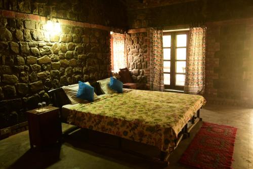 1 dormitorio con 1 cama en una pared de ladrillo en Wild Brook en Rishīkesh