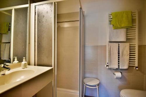 a bathroom with a shower and a sink and a toilet at Hotel Villnerhof in Egna