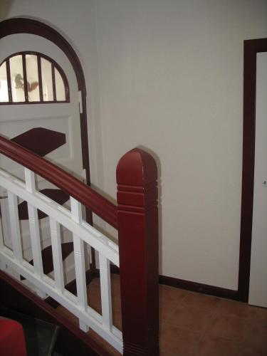 a stairway with a red railing and a white wall at Ferienwohnung Westend-Grunewald in Berlin