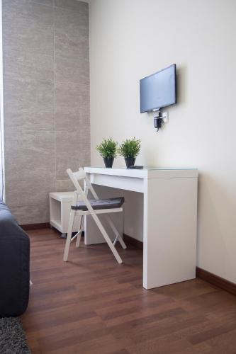 a white desk with a tv on a wall at Furabeach Alojamentos in Furadouro