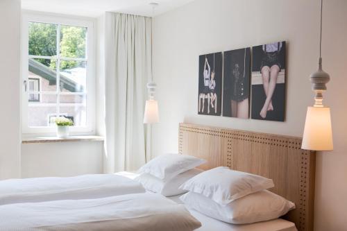 a bedroom with a bed with white sheets and pillows at Genießerhotel Döllerer in Golling an der Salzach