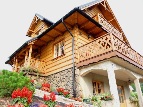 a wooden house with a balcony on top of it at Luxdomki in Szczawnica