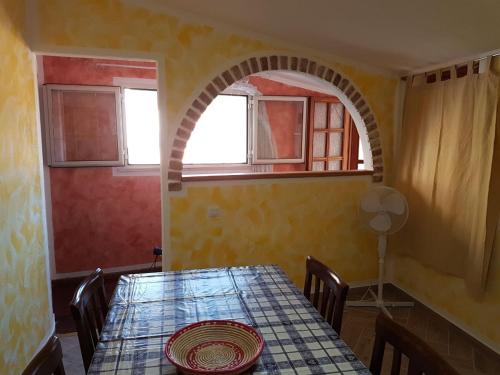 una sala da pranzo con tavolo e finestra di Casa Aurora a Dorgali