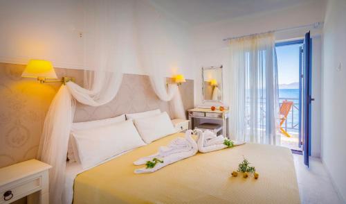Hotel Avlakia في كوكاري: غرفة نوم بيضاء مع سرير عليه زهور