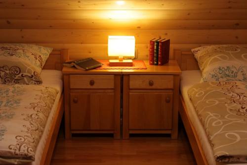 a lamp on a table between two beds in a cabin at Luxdomki in Szczawnica