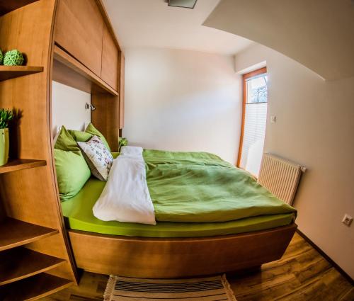 a bedroom with a bunk bed with green sheets at Apartments BBI in Luče