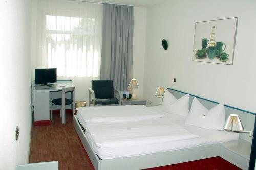 Habitación de hotel con cama y escritorio con ordenador en Keramik Hotel Rheinsberg, en Rheinsberg