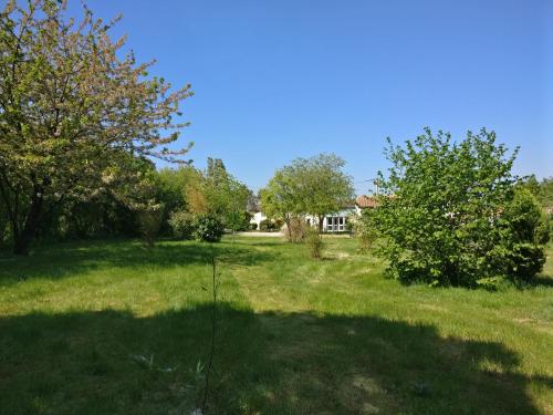 a field of grass with trees and a house at Des Km à La Ronde in La Ronde