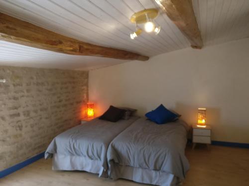 a bedroom with a bed with blue pillows at Des Km à La Ronde in La Ronde