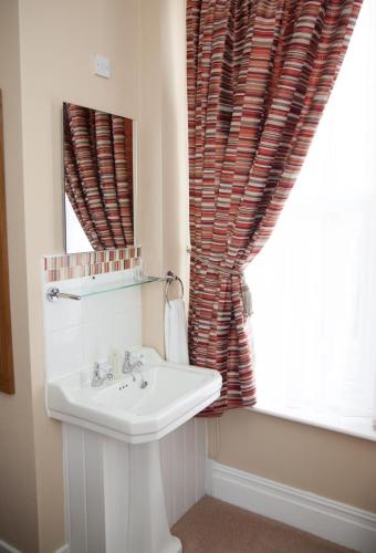 a bathroom with a sink and a window at The Langtons in Eastbourne
