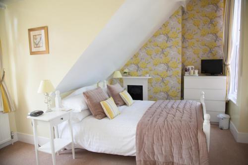 a bedroom with a white bed and a white table at The Langtons in Eastbourne