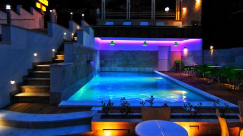 a swimming pool at night with purple lights at Hotel Villa Nadin in Mostar